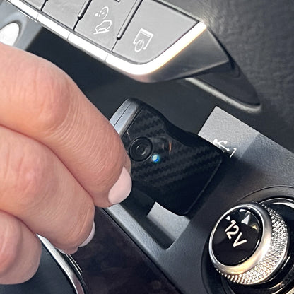 Adapter plugged into car USB port near infotainment screen